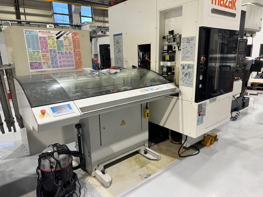 Side view of a used Mazak Integrex J-200 with attached bar feeder – powerful CNC turning and milling centre with automated feed system